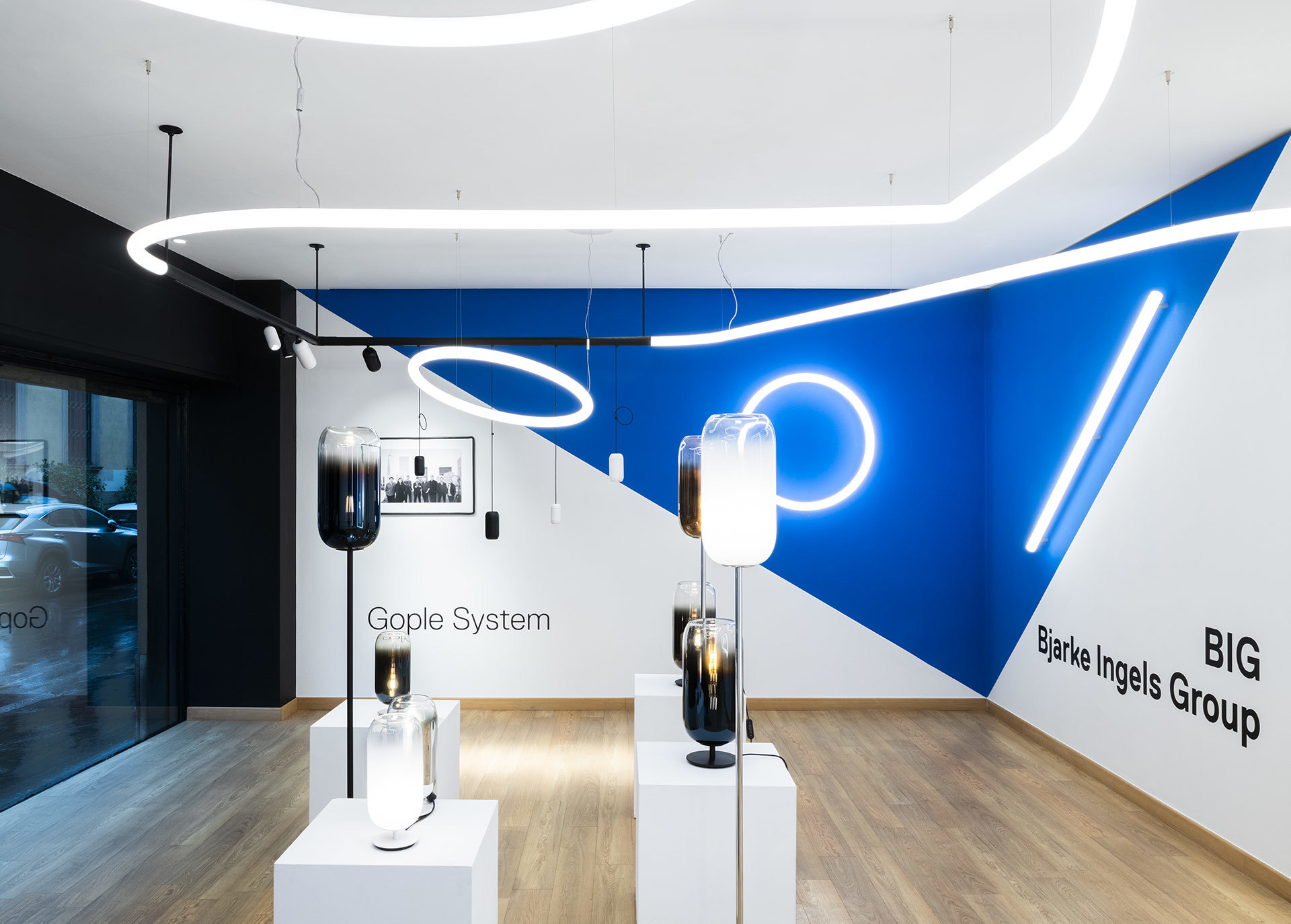 Showroom Artemide con lampade da terra Gople System e sospensioni circolari BIG Bjarke Ingels Group con installazioni lineari a soffitto
