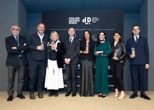 Carlotta de Bevilacqua poses with the group of award recipients during Italian Design Week 2026 in Washington, in front of the event’s official panel.