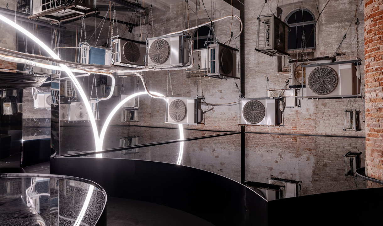 Simbolo del Terzo Paradiso di Michelangelo Pistoletto ricreato con la Linea di Artemide, in una stanza con specchi d’acqua che ne riflettono la forma.