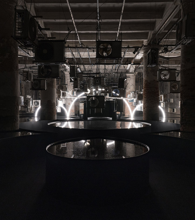 Simbolo del Terzo Paradiso di Michelangelo Pistoletto ricreato con la Linea di Artemide, in una stanza con specchi d’acqua che ne riflettono la forma.