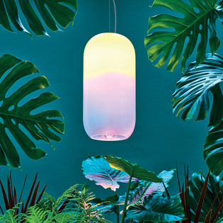 Lampada a sospensione Gople Outdoor tra grandi foglie tropicali, su sfondo verde petrolio. Foto di Pierpaolo Ferrari.