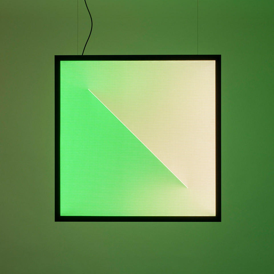 Lampada a sospensione quadrata Artemide Discovery Dialogue con cornice nera, con pannelli luminosi divisi diagonalmente in verde e bianco caldo