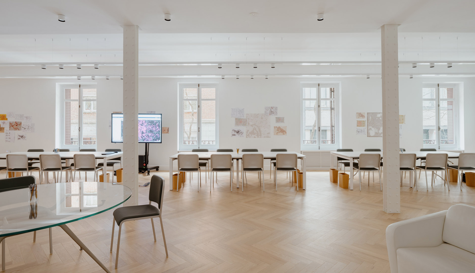 Meeting room with large windows, tables and chairs, illuminated by Hoy System and Hoy Spot.
