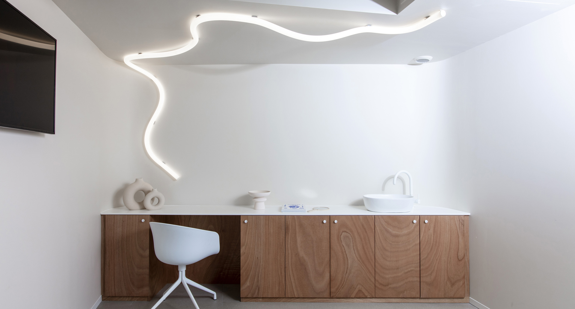 Immagine della stanza dello studio illuminata con La Linea che dal soffitto correndo arriva fino alla parete.