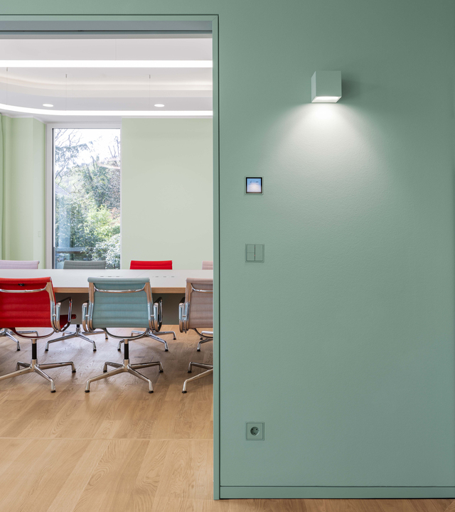 Image of Aede positioned in the corridor and view of the meeting room.