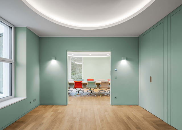 Image of the corridor with two Aede on the wall and a glimpse of the meeting room.