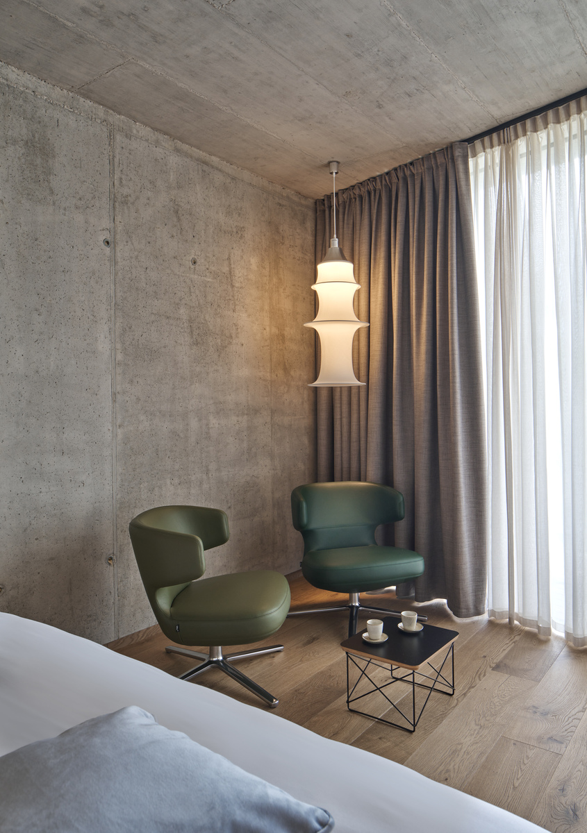 Image of two armchairs inside a hotel room illuminated by Falkland Suspension.