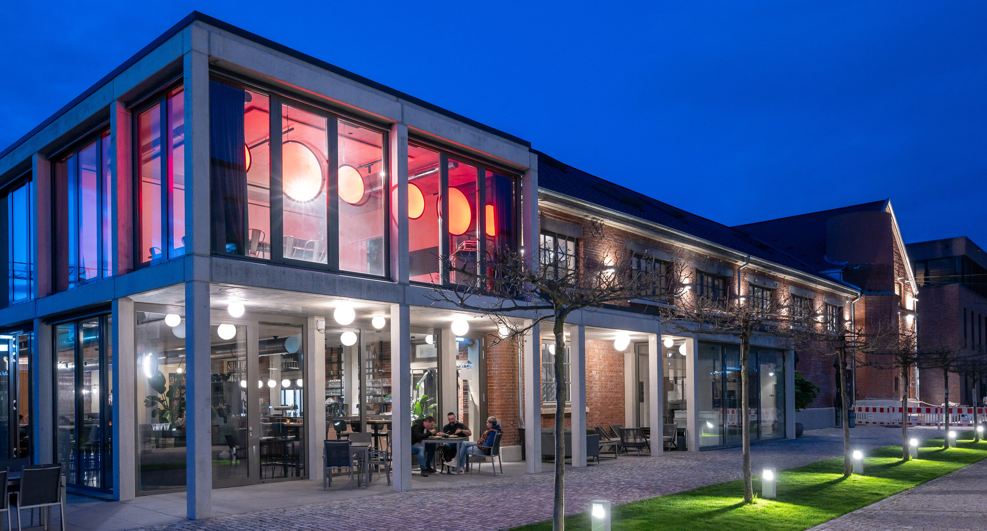 Image of the outside of the event venue, the veranda lit by Dioscuri Ceiling and inside you can see a series of Discovery Vertical.